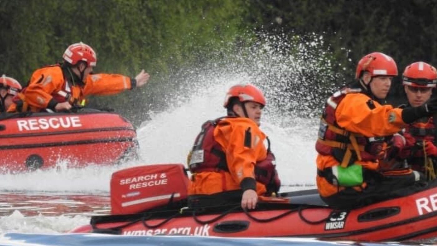 Search and rescue boat with staff trying to help resident